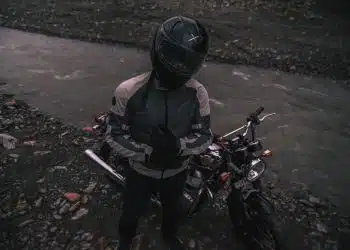 a person sitting on a motorcycle next to a river