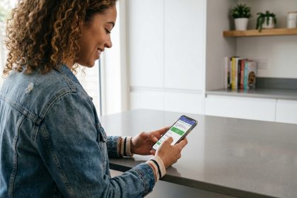 Jeune femme souriante utilisant une application de conduite à la maison